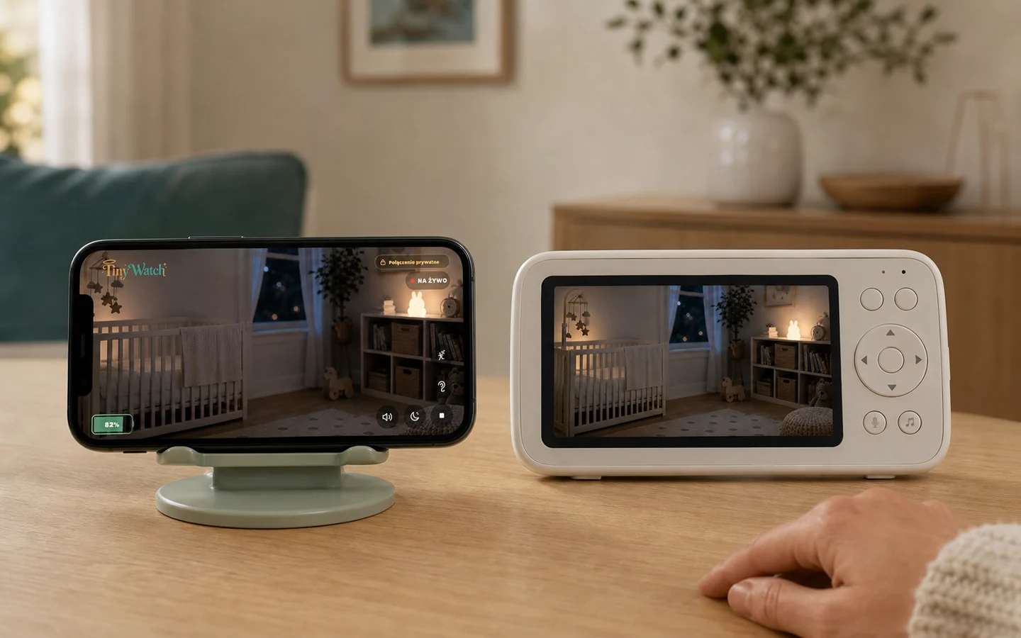 An iPhone with the TinyWatch live view beside a dedicated baby monitor receiver